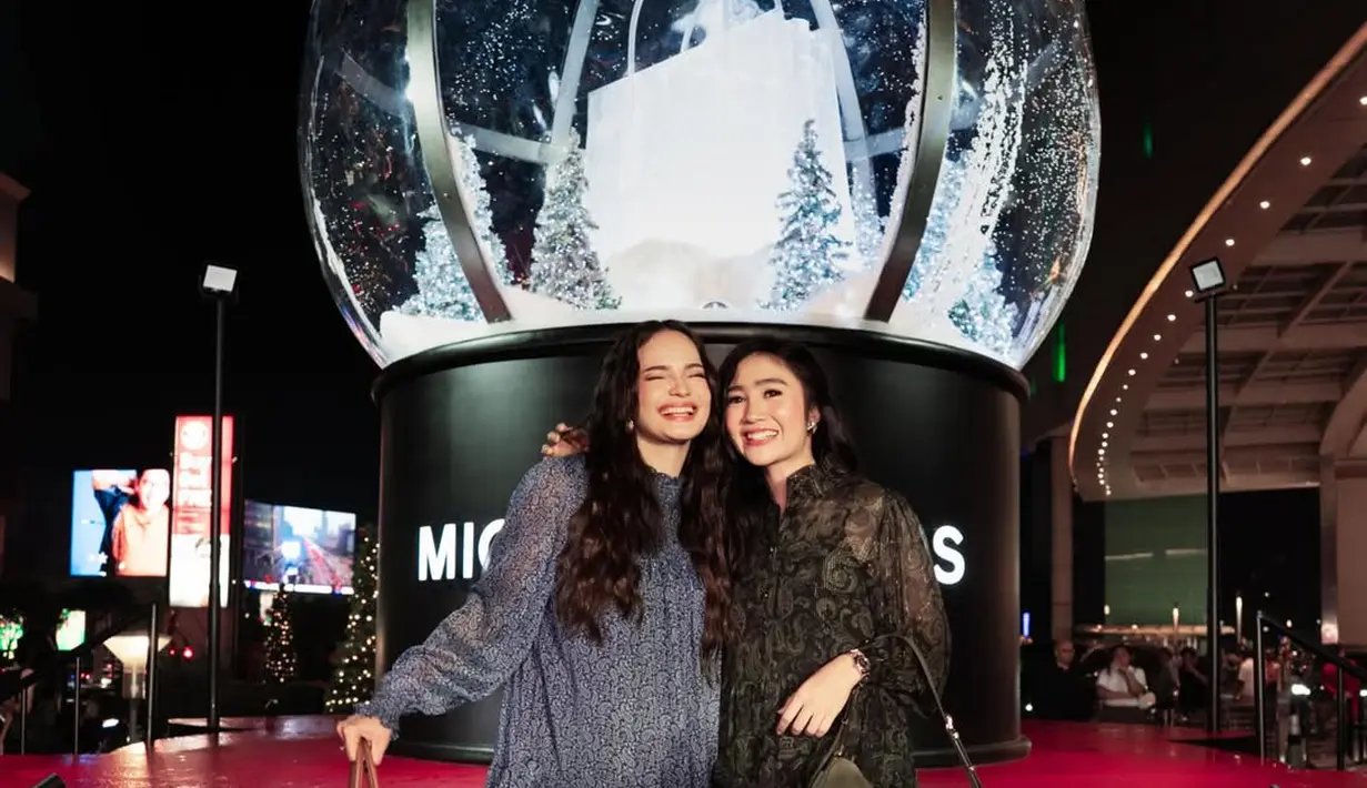 Febby Rastanty kenakan busana yang mirip dengan Alika namun dalam siluet dress. Ia pun melengkapi tampilan femininnya dengan heels hitam dan Nubuck Bag hijau olive