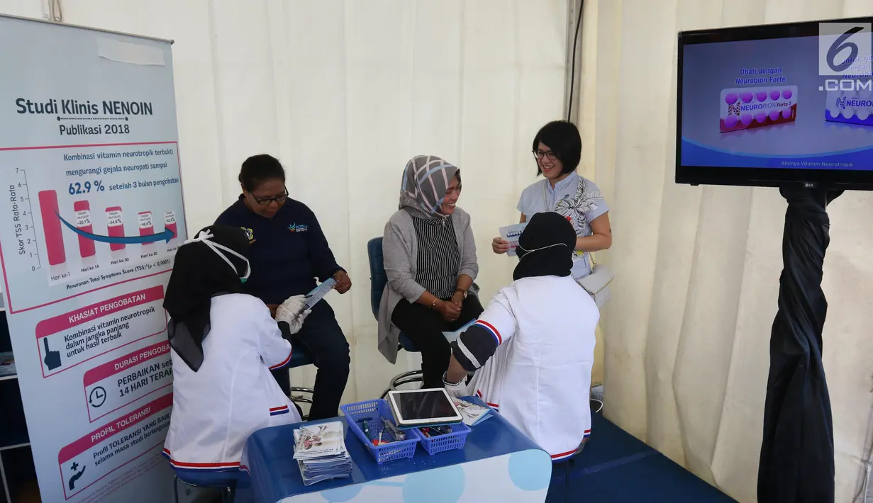 Chitra Ariesta, Consumer Health Brand Manager Neurobion, PT P&G Health Indonesia (kanan) tengah mendampingi warga lansia yang memeriksakan kesehatan saraf di booth Neuropathy Check Point. saat CFD di Jakarta, Minggu (7/7/2019). (Liputan6.com/Angga Yuniar)