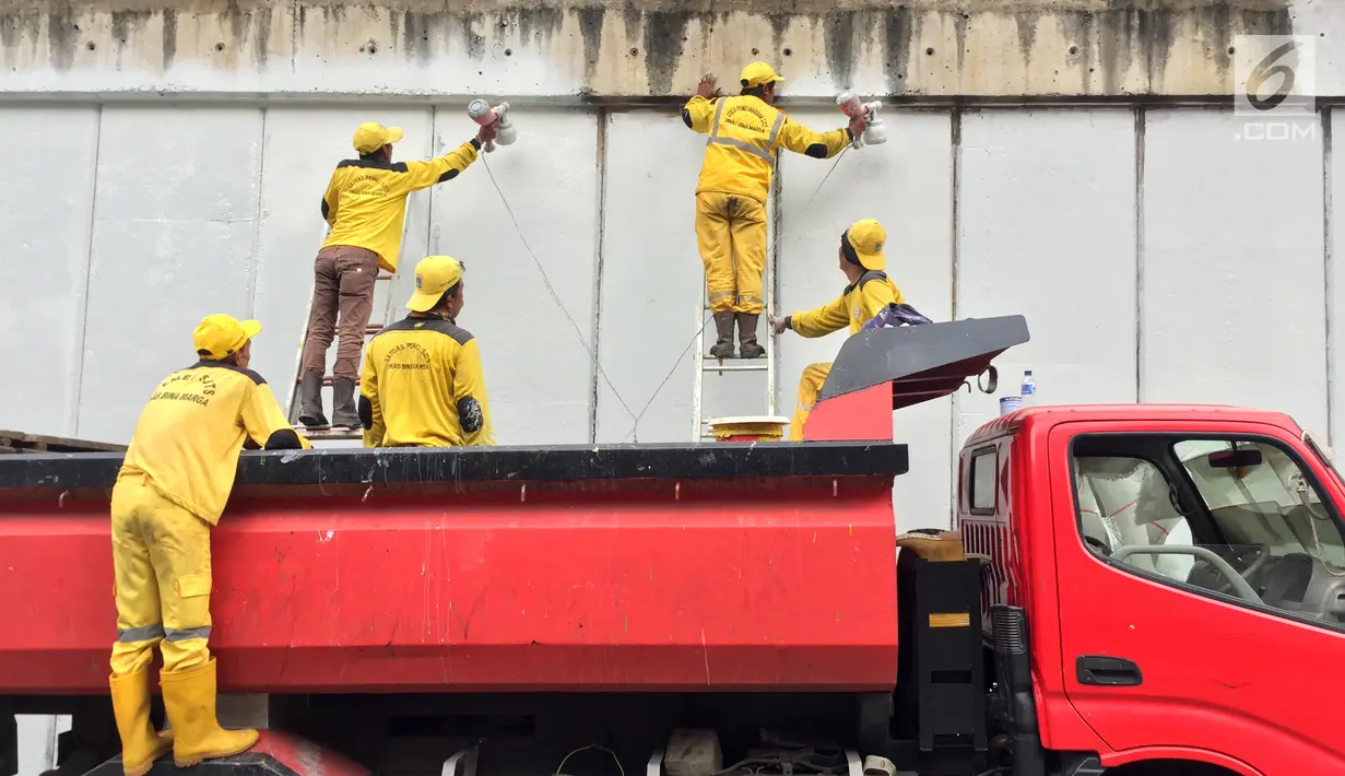 Pasukan Kuning mengecat dinding Underpass Kebayoran Baru, Jakarta Selatan, Kamis (1/2). Pengecatan dilakukan sebagai bentuk perawatan. (Liputan6.com/Immanuel Antonius)