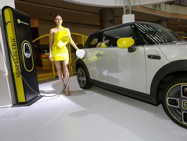 Model berpose di samping mobil MINI Electric pada peluncuran MINI Electric di PIK Avenue Jakarta (08/06/2022). MINI Indonesia hadirkan kendaraan full listrik premium dalam dua varian yaitu MINI Electric dan MINI Electric Collection dengan motor listrik 135 kW/184 hp dan tenaga maksimum 270 Nm. (Liputan6.com/Fery Pradolo)