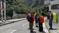 Turis menunggu di luar stasiun kereta Machu Picchu setelah layanan kereta api dihentikan karena kerusakan yang diduga disebabkan oleh pengunjuk rasa di Machu Picchu, Peru, Sabtu (21/1/2023). Puluhan orang telah terbunuh dengan demonstrasi penuh kekerasan yang terjadi selama beberapa pekan terakhir. (Photo by Carolina Paucar / AFP)