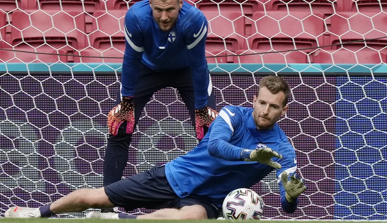 Kiper timnas Finlandia, Lukas Hradecky melompat untuk mengambil bola selama sesi latihan tim di stadion Parken di Kopenhagen, Jumat (11/6/2021). Timnas Denmark akan berhadapan dengan Timnas Finlandia pada laga pembuka Grup B Euro 2020, Sabtu (12/6) malam. (AP Photo/Martin Meissner)
