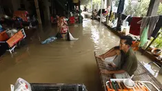 Seorang pria duduk di ranjang bambu saat banjir menyusul hujan di pinggiran Phnom Penh, Kamboja (14 /10/2020). Pejabat bencana Kamboja mengatakan Rabu bahwa lebih dari 10.000 orang telah dievakuasi ke tempat aman setelah badai tropis melanda yang menyebabkan banjir bandang. (AP Photo/Heng Sinith)