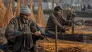 Penduduk desa Kashmir mengupas penutup rotan di pinggiran Srinagar, Kashmir yang dikuasai India, Selasa (30/11/2021). Anyaman digunakan untuk membuat tungku tradisional yang disebut Kangri di Kashmir. (AP Photo/Dar Yasin)