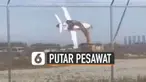 Alat berat itu menjepit rongsokan badan pesawat dan memutar-mutarnya seperti wahana taman rekreasi.