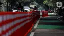 Pengendara melintasi di sebelah rute sepeda di kawasan Jalan Tentara Pelajar, Patal Senayan, Jakarta, Kamis (20/10/2022). Setidaknya terdapat 26 ruas rencana pembangunan lajur sepeda di wilayah DKI Jakarta. (Liputan6.com/Johan Tallo)