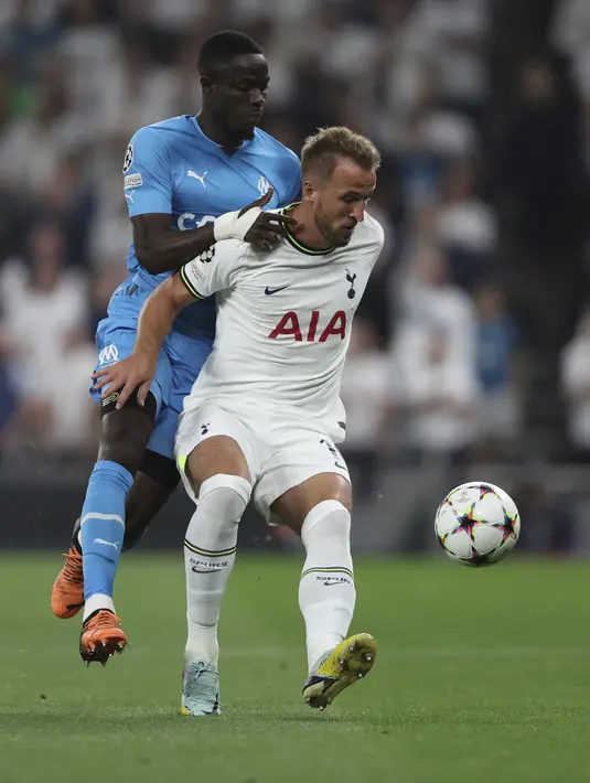 Bek Marseille, Eric Bailly berusaha merebut bola dari penyerang Tottenham, Harry Kane selama pertandingan  Grup D Liga Champions di stadion Tottenham Hotspur, di London, Inggris, Kamis (8/9/2022). Dengan kemenangan ini, Tottenham berada di peringkat kedua klasemen dengan 3 poin. (AP Photo/Ian Walton)