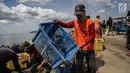 Petugas kebersihan membawa sampah  laut di Pelabuhan Kali Adem, Jakarta, Senin (1/1). Banyaknya sampah plastik dibandingkan ikan yang gagal dikelola dengan baik membuat limbah yang mengakibatkan laut tercemar. (Liputan6.com/Faizal Fanani)