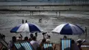 Mereka terlihat menikmati panas matahari sambil berjemur. (HENRY NICHOLLS/AFP)