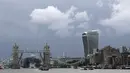 Perahu menyusuri Sungai Thames di depan Tower Bridge London yang terjebak dalam posisi terbuka penuh, Senin (9/8/2021). Tower Bridge London macet terbuka mengakibatkan gangguan lalu lintas di kedua sisi Sungai Thames karena mobil dan pejalan kaki tidak dapat menyeberang. (AP/Tony Hicks)