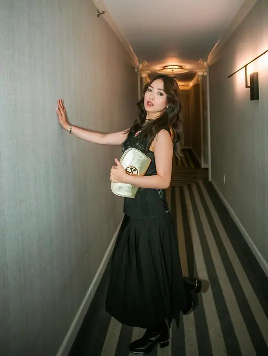 Natasha Wilona kenakan dress hitam dan boots saat hadir di show Tory Burch. Ia pun jinjing clutch gold yang stunning [@natashawilona12]