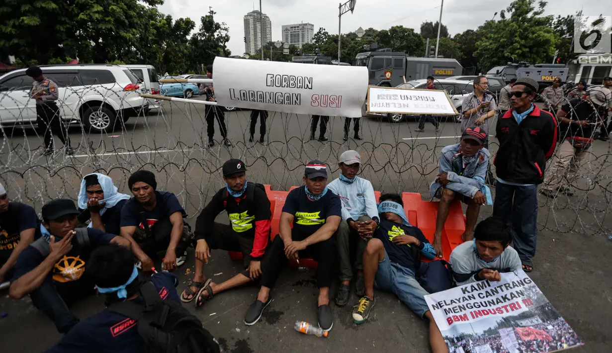 Ribuan nelayan tradisional beristirahat saat unjuk rasa menolak larangan penggunaan cantrang di depan Istana Negara, Jakarta Pusat, Rabu (17/1). Penggunaan cantrang dilarang karena sistem kerjanya mengeruk dari dasar laut. (Liputan6.com/Faizal Fanani)