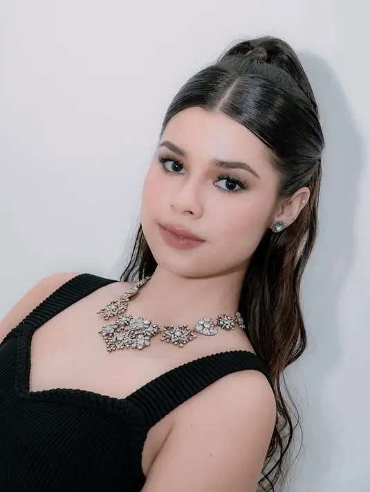Rambut Maria ditata dengan gaya sleek, setengah terikat ke atas dan bagian bawah dibiarkan bergelombang, memberikan kesan natural namun tetap glamor  [@mariatheodoree].