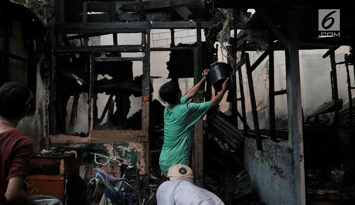 Warga membantu petugas pemadam kebakaran menjinakkan kobaran api yang membakar permukiman di kawasan Tanah Tinggi, Johar Baru, Jakarta, Selasa (26/6). Sebanyak 20 mobil pemadam kebakaran turut dikerahkan. (Merdeka.com/Iqbal Nugroho)