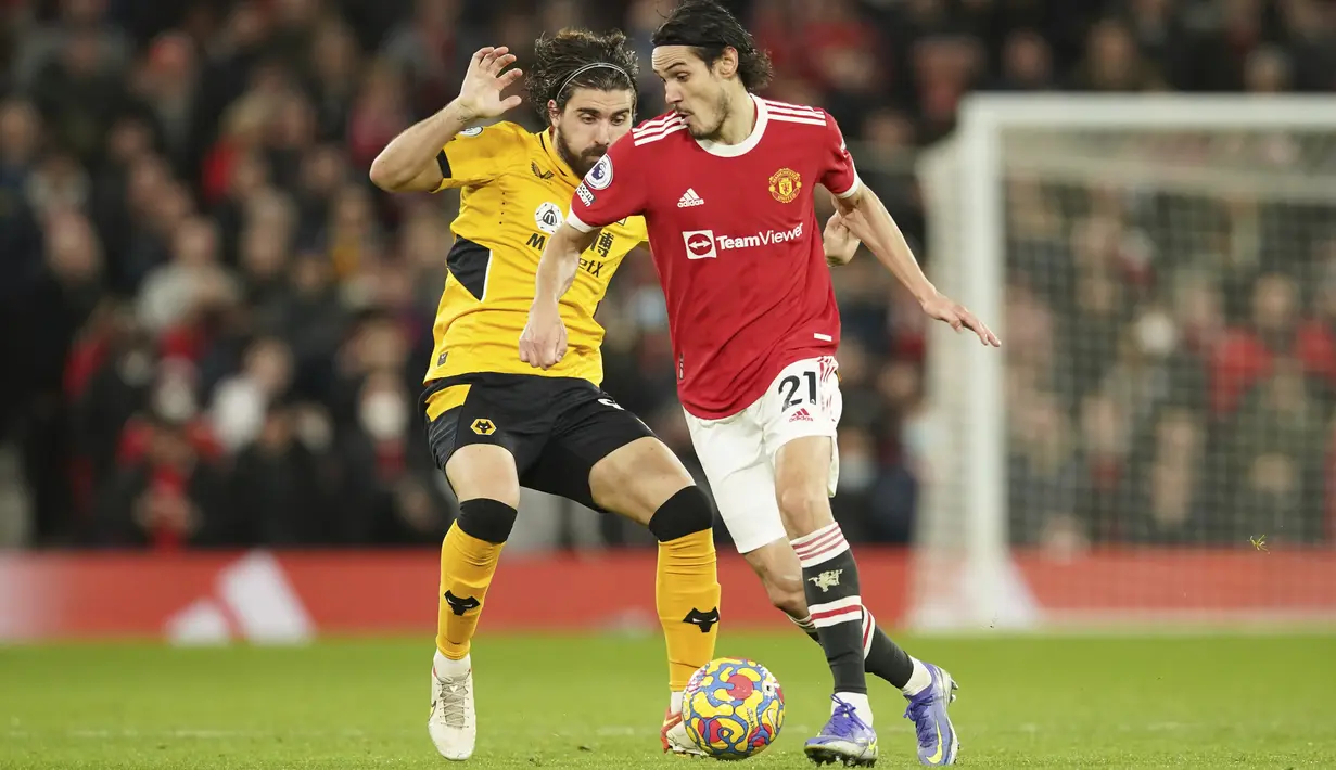 Gelandang Wolverhampton Wanderers Ruben Neves berebut bola dengan penyerang Manchester United (MU) Edinson Cavani dalam pekan ke-22 Liga Primer Inggris di Old Trafford, Selasa (4/1/2022) dini hari WIB. MU takluk 0-1 saat menjamu Wolves. (AP Photo/Dave Thompson)