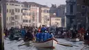 Peserta mengenakan kostum sambil mendayung perahu menyusuri Grand Canal pada parade upacara pembukaan karnaval Venesia di Italia, 28 Januari 2018. Karnaval Venesia pertama kali diselenggarakan pada abad ke-11.  (AFP Photo / FILIPPO MONTEFORTE)