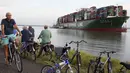 Pengendara sepeda melihat kapal kontainer CSCL Jupiter Hong Kong yang terdampar di muara Westerschelde di dekat kota Bath di Belanda setelah insiden grounding (14/8).  (AFP PHOTO/Belga/Kristof Van Accom/Belgium Out)