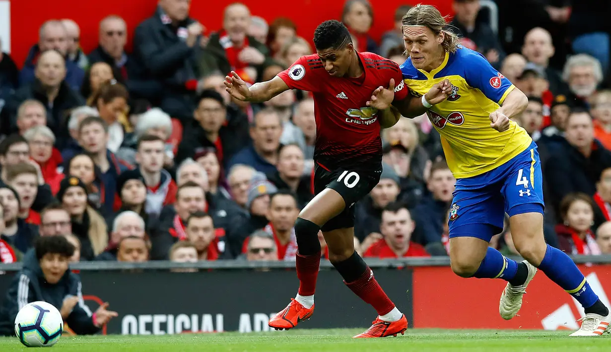 Striker Manchester United, Marcus Rashford berusaha melewati pemain Southampton, Jannik Vestergaard selama pertandingan lanjutan Liga Inggris di stadion Old Trafford, (2/3). MU menang tipis 3-2 atas Southampton. (Martin Rickett /PA via AP)
