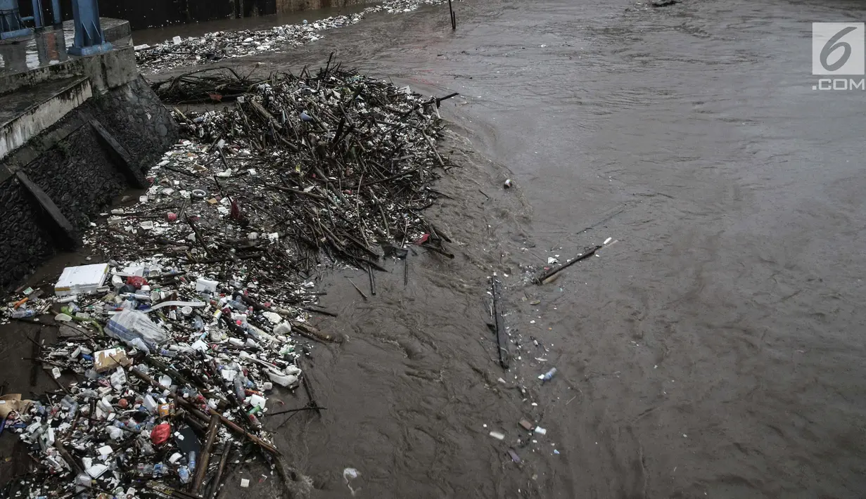 Tumpukan sampah menumpuk di Pintu Air Manggarai, Jakarta, Senin (5/2). Sampah-sampah tersebut terbawa oleh arus banjir kiriman dari Bogor. (Liputan6.com/Faizal Fanani)
