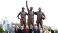 Patung George Best (kiri), Dennis Law (tengah), dan Bobby Charlton (kanan) berada di depan Old Trafford untuk mengingat kejayaan para legenda Manchester United itu. (AFP/Paul Ellis)
