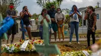 Kerabat korban COVID-19 menghadiri pemakaman di Brasil, di mana jumlah kematian setiap hari melonjak. (AFP / MICHAEL DANTAS)