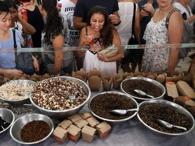Sejumlah orang melihat jajanan yang berbahan dasar utama dari serangga, Sydney, Australia, Sabtu (28/4). Kecoa panggang, semut rasa madu, larva berlapis coklat dsb tersedia di kios tersebut. (AFP FOTO / ANDREW MURRAY )