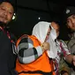 Sri Hartini dikawal petugas polisi meninggalkan gedui KPK usai menjalani pemeriksaan, Jakarta, Sabtu (31/12). KPK menetapkan Bupati Klaten Sri Hartini dan Suramlan terkait dugaan kasus suap pengaturan jabatan. (Liputan6.com/Helmi Afandi)