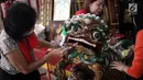 Seorang ibu menggosok patung menggunakan sikat saat aksi bersih-bersih di Vihara Amurva Bhumi, Jakarta, Kamis (8/2). Dengan suka cita,masyarakat Tionghoa membersihkan seluruh patung dewa-dewi serta perlengkapan ibadah. (Liputan6.com/Arya Manggala)