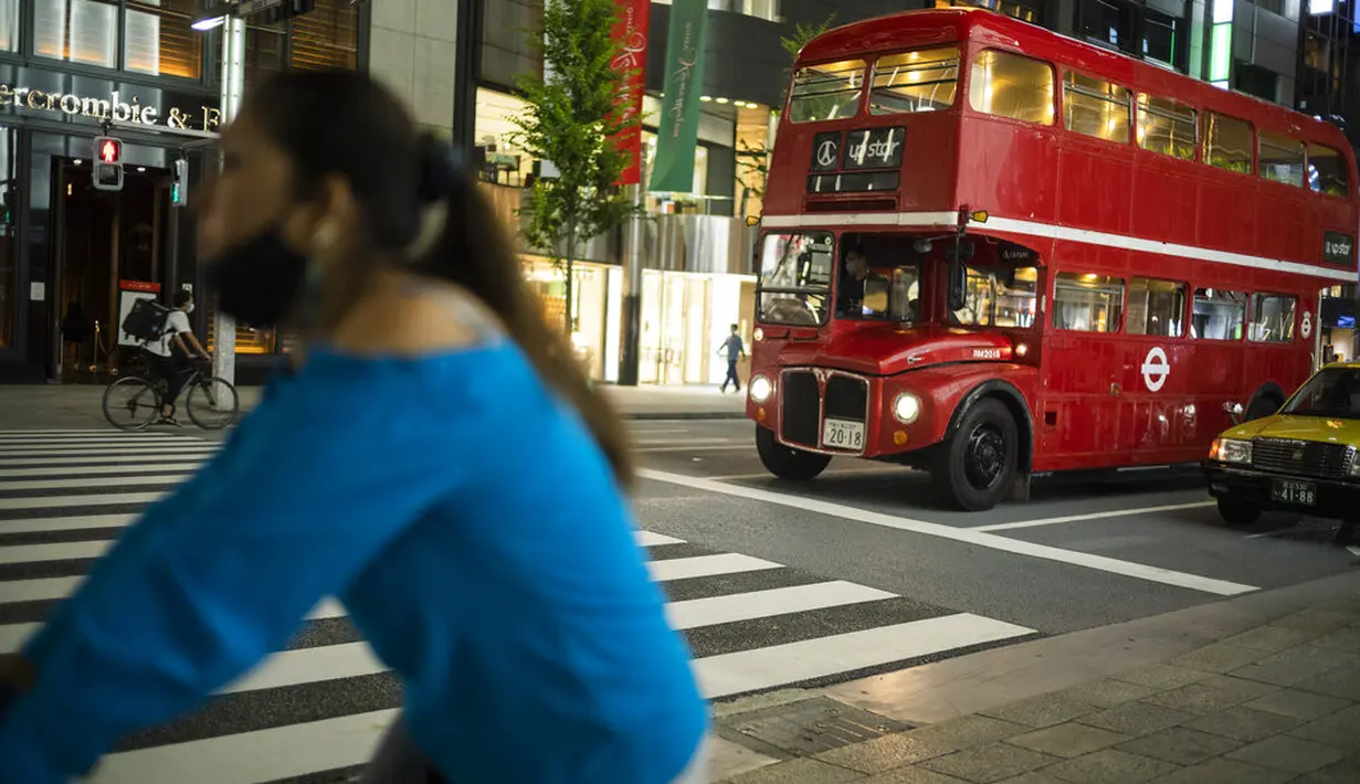 Sebuah bus bertingkat yang digunakan untuk iklan melintasi kota menunggu di lampu lalu lintas di distrik perbelanjaan Ginza Tokyo, Kamis (23/9/2021). Kawasan ini dikenal sebagai kawasan mewah di Tokyo. (AP Photo/Hiro Komae)