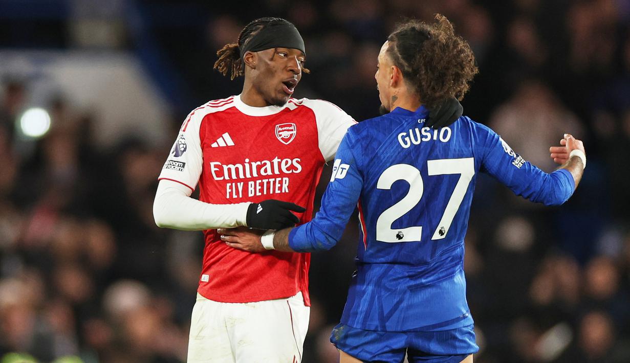 Pemain Arsenal, Noni Madueke (kiri) bersalaman dengan pemain Chelsea, Malo Gusto setelah berakhirnya laga lanjutan Liga Inggris 2025/2026 di Stamford Bridge, London, Minggu (30/11/2025). (AP Photo/Ian Walton)