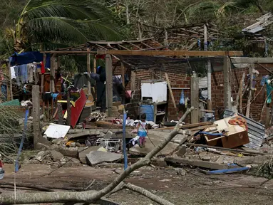 Seorang anak melihat rumahnya yang rusak parah akibat terkena Badai Patricia, Meksiko, Sabtu (24/10/2015). Pusat Badai Nasional AS di Miami mengatakan badai tersebut  berada pada level 5 dengan kecepatan angin 265km/jam. (Reuters/Henry Romero)