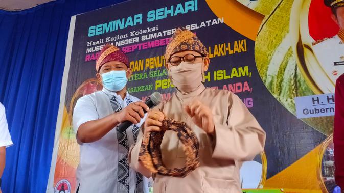 Budayawan dan Sejarahwan Sumsel, Raden Muhammad Ali Hanafiah, saat menunjukkan cara membuat tanjak, saat seminar di Museum Negeri Sumsel (Liputan6.com / Nefri Inge)