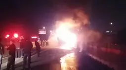 Kobaran api terlihat membakar badan bus berpenumpang sekelompok wisatawan lokal di Gyeongbu Expressway, tenggara Kota Ulsan, Korea Selatan, Kamis (13/10) malam. Sedikitnya 10 orang tewas dan tujuh lainnya luka berat akibat insiden itu. (Yonhap/AFP)