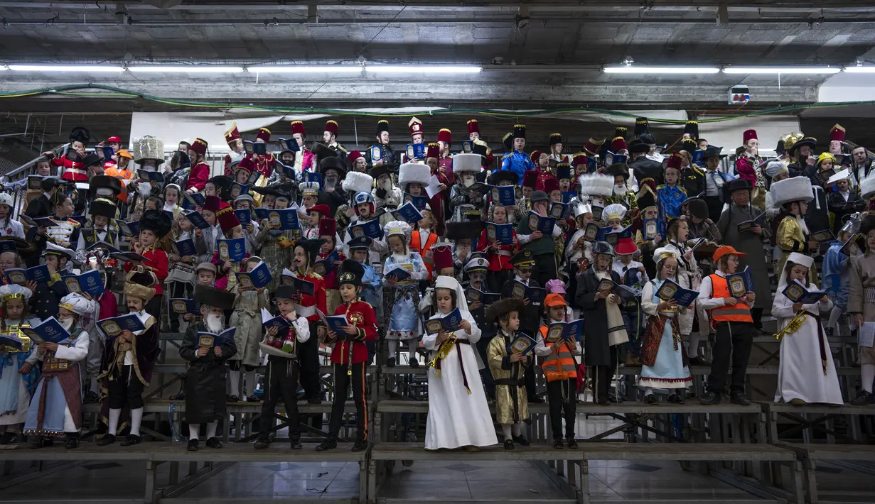 Anak-anak Yahudi ultra-Ortodoks mengenakan kostum saat mereka merayakan festival Yahudi Purim di sebuah sinagoga di Bnei Brak, Israel, Senin (6/3/2023). Purim dirayakan tiap tahun menurut kalender Ibrani oleh kaum Yahudi. (AP Photo/Oded Balilty)