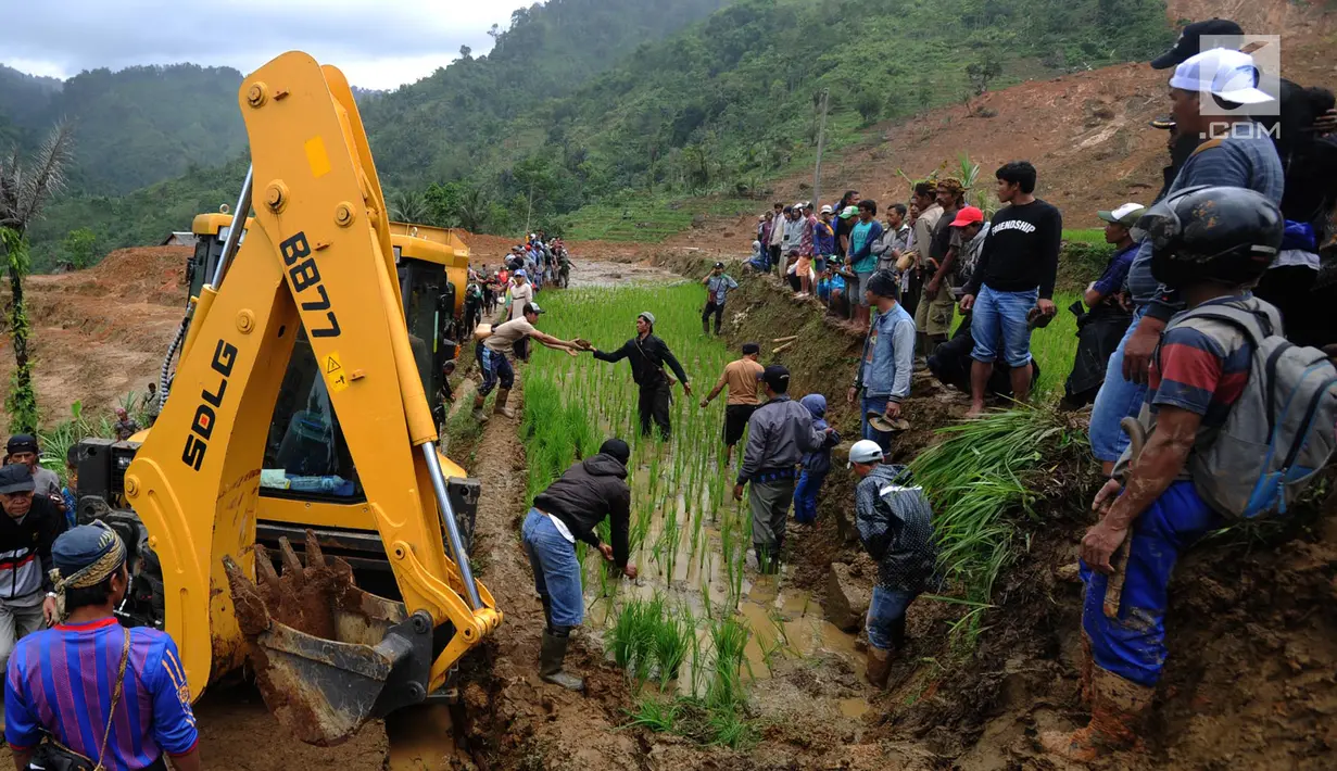 Warga memandu alat berat melalui jalan kecil menuju lokasi longsor di Dusun Cimapag, Sirnaresmi, Cisolok, Sukabumi, Jawa Barat, Selasa (1/1). Alat berat dikerahkan untuk mencari korban yang hilang. (Merdeka.com/Arie Basuki)