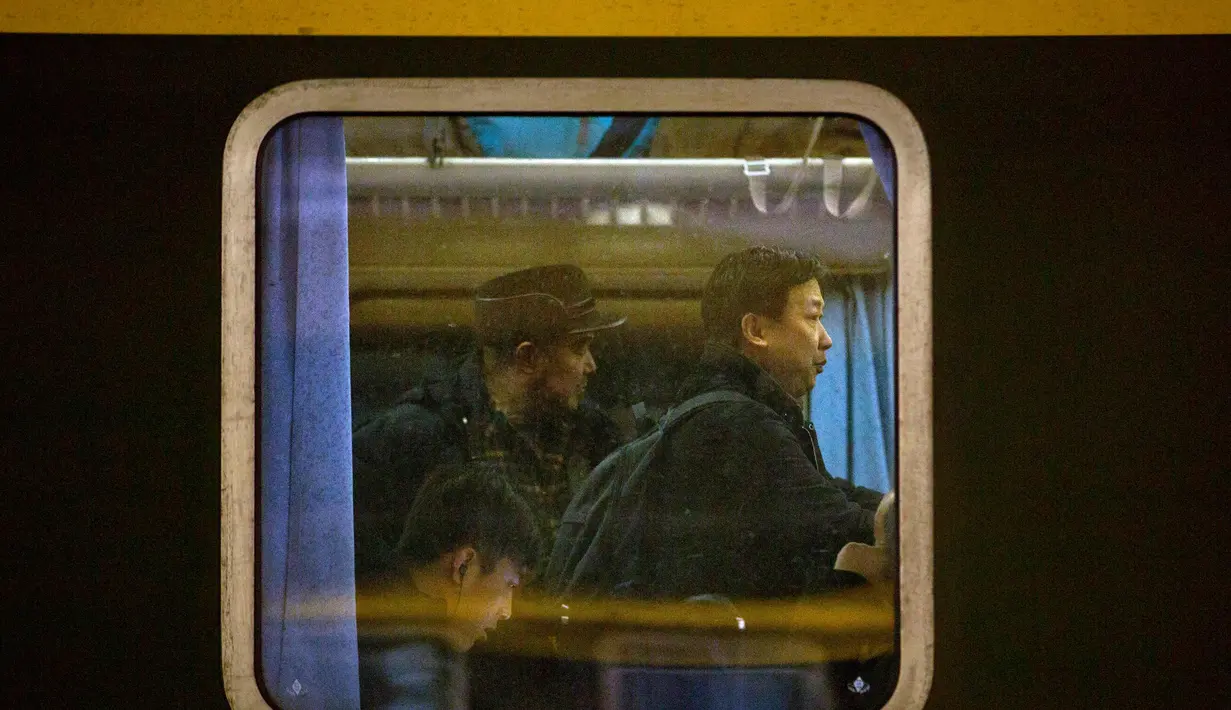 Warga berada di dalam kereta di Stasiun Kereta Api Beijing, (9/2). Sambut perayaan Imlek 2018, Jutaan warga China mulai memenuhi stasiun, bandara dan jalan yang diperkirakan akan dimulai akhir pekan ini. (AP Photo / Mark Schiefelbein)