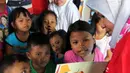 Anak-anak korban gempa tsunami Palu mendengarkan cerita bergambar di halaman kantor Dinas Sosial Palu, Sulawesi Tengah, Sabtu (6/10). Trauma healing juga diberikan agar anak-anak percaya diri dan kembali ceria. (Liputan6.com/Fery Pradolo)