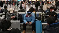 Calon penumpang menunggu kereta di Stasiun Hongqiao, Shanghai China, 11 Januari 2023. Migrasi tahunan di China dimulai dengan orang-orang kembali ke kampung halaman mereka untuk merayakan Tahun Baru Imlek. (Hector RETAMAL/AFP)