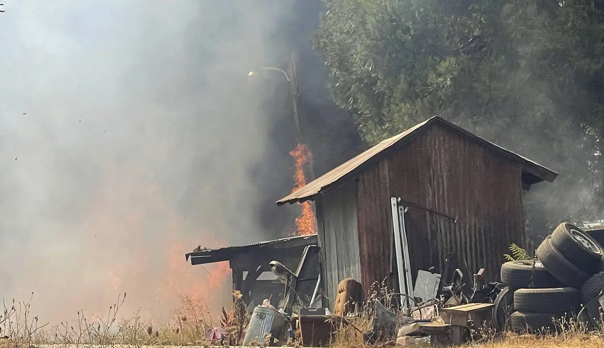 Sebuah tiang listrik dan beberapa bangunan luar rusak jika tidak dihancurkan dalam kebakaran di Idaho Maryland di Grass Valley, California, Rabu (25/8/2021). (Elias Funez/The Union via AP)