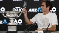Juara Australia Terbuka 2018 Roger Federer mengajak bersulang pada konferensi pers usai mengalahkan Marin Cilic di final, Minggu (28/1/2018). (AP Photo/Vincent Thian)