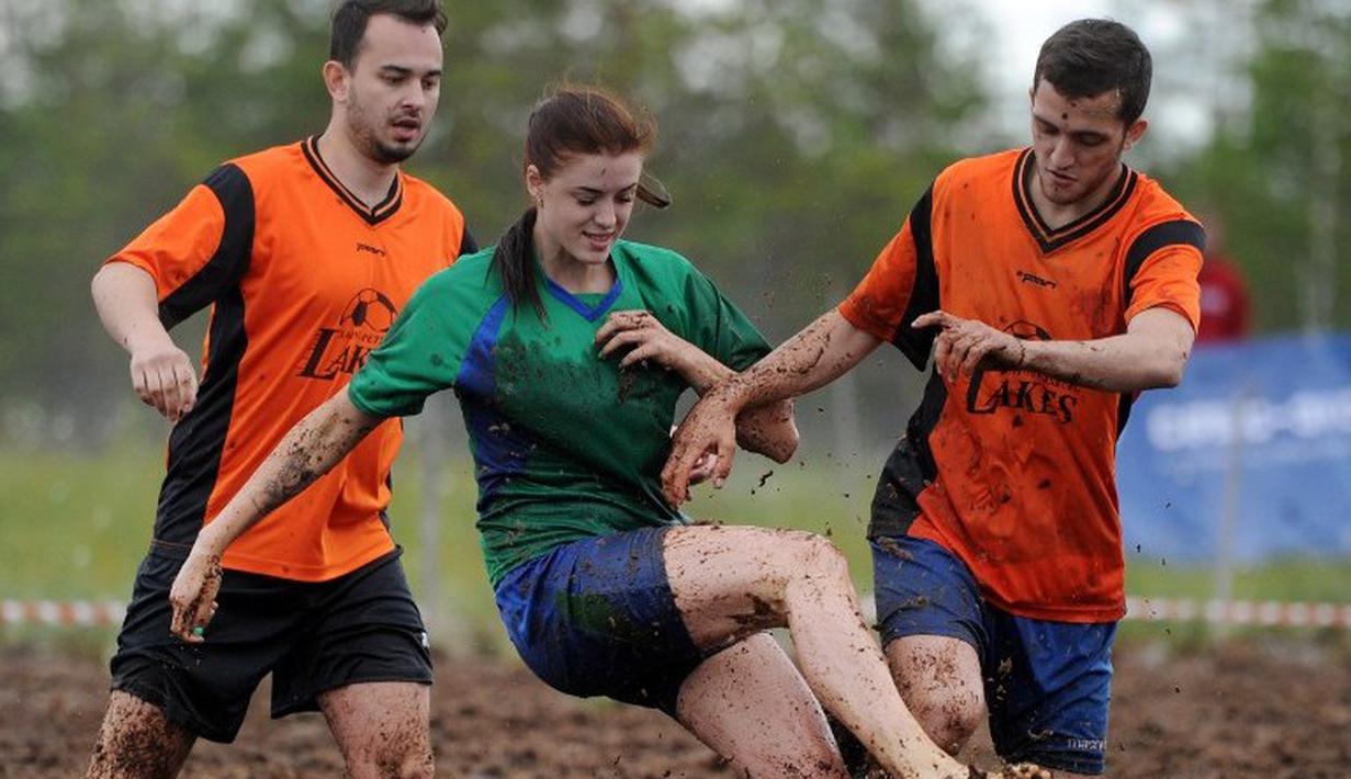 Pemain sepak bola rawa berebut bola dalam turnamen memperebutkan Piala Rusia yang berlangsung di Saint Petersburg, Rusia. Sabtu (27/6). (AFP PHOTO/OLGA MALTSEVA)