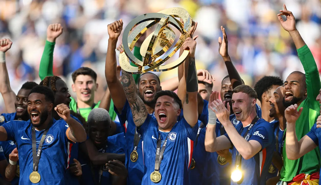 Gelandang Chelsea asal Argentina, Enzo Fernandez mengangkat trofi bersama rekan setimnya setelah berhasil meraih gelar juara Piala Dunia Antarklub 2025 di Stadion MetLife, East Rutherford, New Jersey, Amerika Serikat pada 13 Juli 2025 waktu setempat atau Senin (14/7/2025) dini hari WIB. (ANGELA WEISS/AFP)