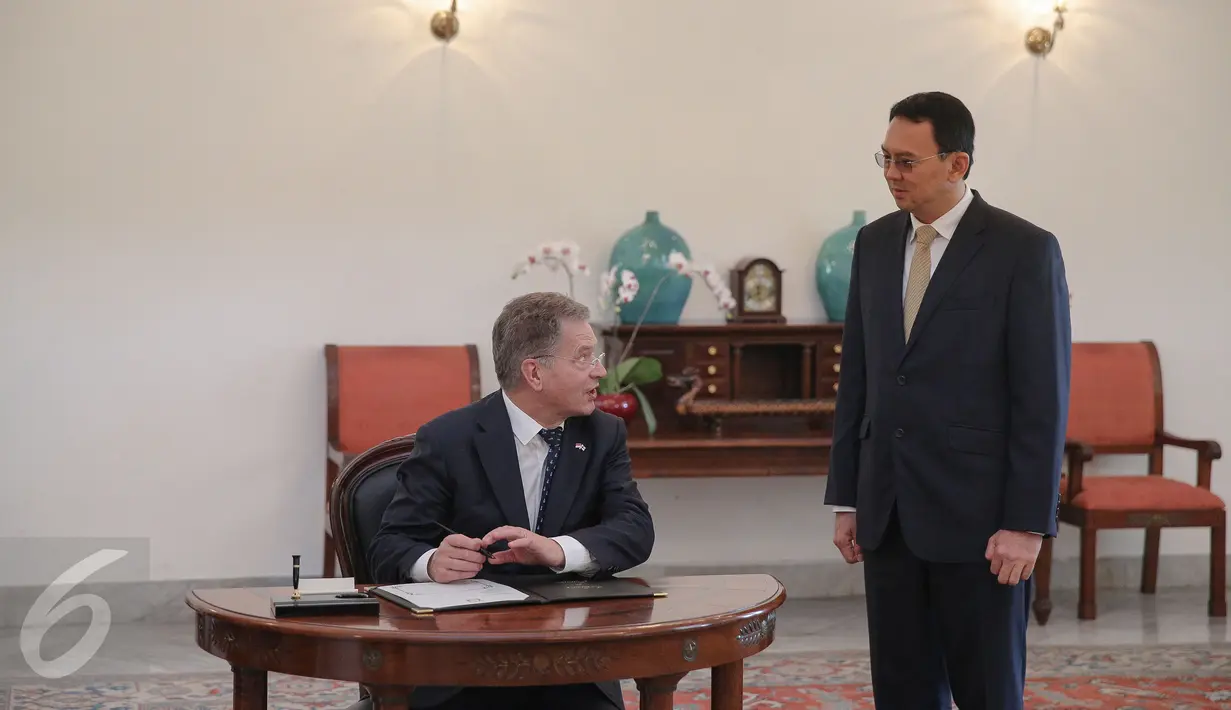 Presiden Finlandia Sauli Vainamo Niinisto (kiri) berbincang dengan Gubernur DKI Basuki Tjahaja Purnama sebelum mengisi buku tamu di Balai Kota DKI Jakarta, Rabu (4/11). Pertemuan keduanya membahas peluang kerjasama. (Liputan6.com/Faizal Fanani)