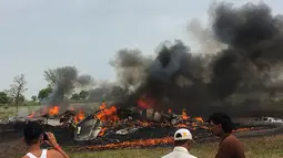 Sejumlah warga melihat pesawat MiG-27 yang terbakar setelah jatuh saat misi rutin di sekitar desa Devariya dekat Jodhpur, India, (4/9). Menurut media lokal, pilot pesawat selamat dan tidak ada korban jiwa akibat insiden tersebut. (AFP Photo)