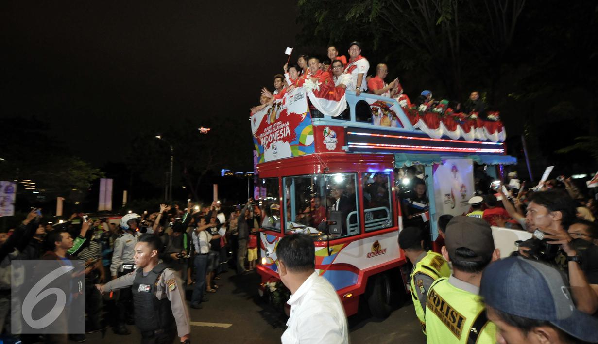 Arak-arakan atlet peraih medali Olimpiade Rio 2016 disambut meriah oleh warga, Senayan, Jakarta, Selasa (23/8). Setibanya di Tanah Air, atlet Olimpiade diarak menggunakan bus Bamdros menuju gedung Kemenpora. (Liputan6.com/Yoppy Renato)