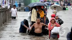 Tampak seorang bapak penarik jasa gerobak saat membawa penumpang untuk melawati banjir, Jakarta, Senin (6/2/2015). Jasa gerobak Mematok harga Rp. 30 ribu untuk membawa motor sedangkan untuk per orang hanya Rp. 10 ribu. (Liputan6.com/Faizal Fanani)