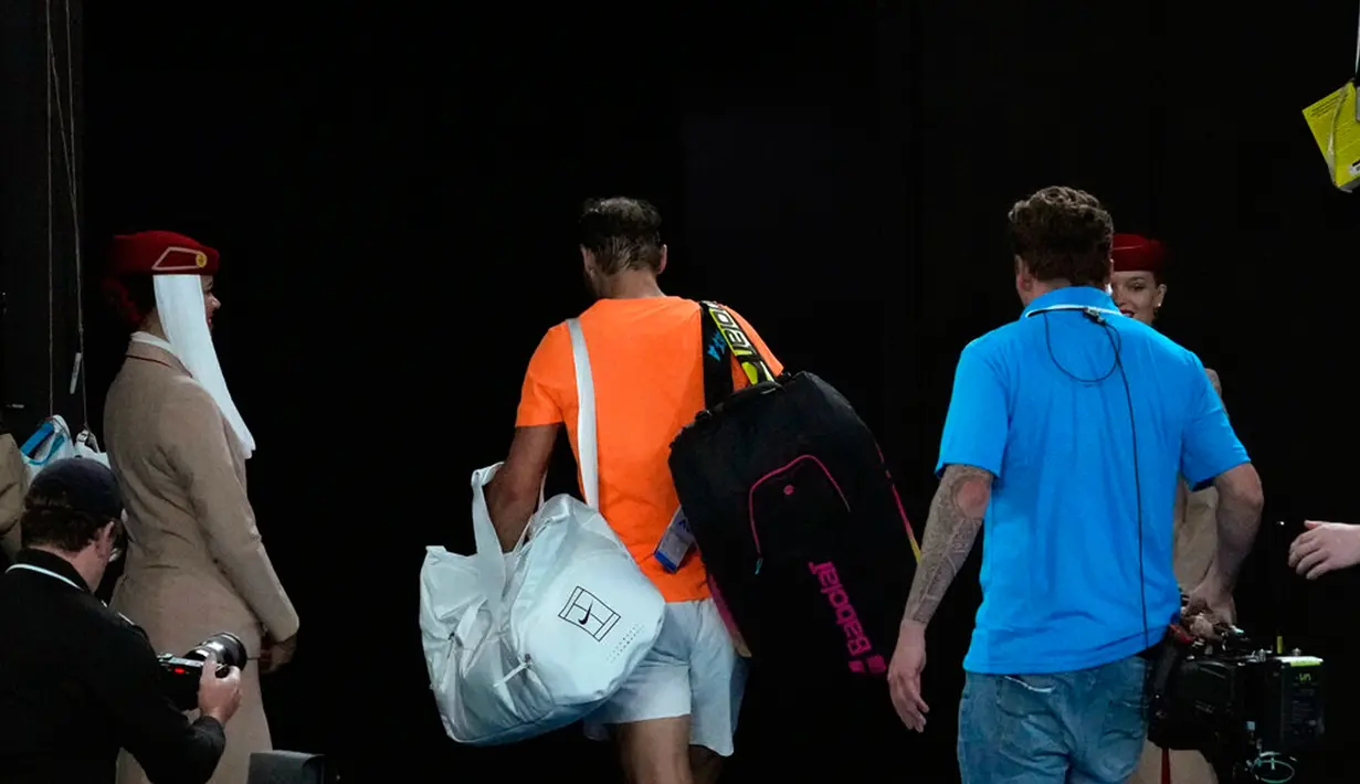 Petenis Spanyol Rafael Nadal meninggalkan Rod Laver Arena menyusul kekalahannya atas petenis Spanyol Mackenzie McDonald pada pertandingan putaran kedua kejuaraan tenis Australian Open di Melbourne, Australia, Rabu (18/1/2023). Rafael Nadal harus tersingkir dari Australian Open 2023 setelah ia mengalami cedera dan kemudian takluk 4-6, 4-6, 5-7 dari petenis Amerika Serikat MacKenzie McDonald. (AP Photo/Dita Alangkara)