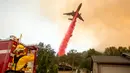 Pemadam kebakaran menggunakan pesawat membuang fire retardant untuk mengatasi kebakaran di Mariposa, California (19/7). Lebih dari 1.400 petugas pemadam kebakaran dikerahkan untuk menagatasi kebakaran tersebut. (AFP Photo/Josh Edelson)