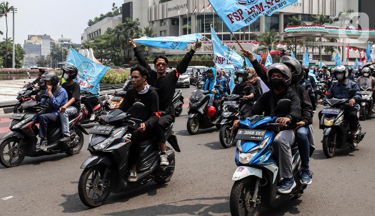 Buruh mengibarkan bendera saat melakukan konvoi menggunakan sepeda motor di Bundaran Hotel Indonesia untuk mengikuti unjuk rasa di depan Gedung DPR, Jakarta, Rabu (10/8/2022). Dalam aksi tersebut mereka menuntut agar pemerintah menghapus Omnibus Law. (Liputan6.com/Johan Tallo)
