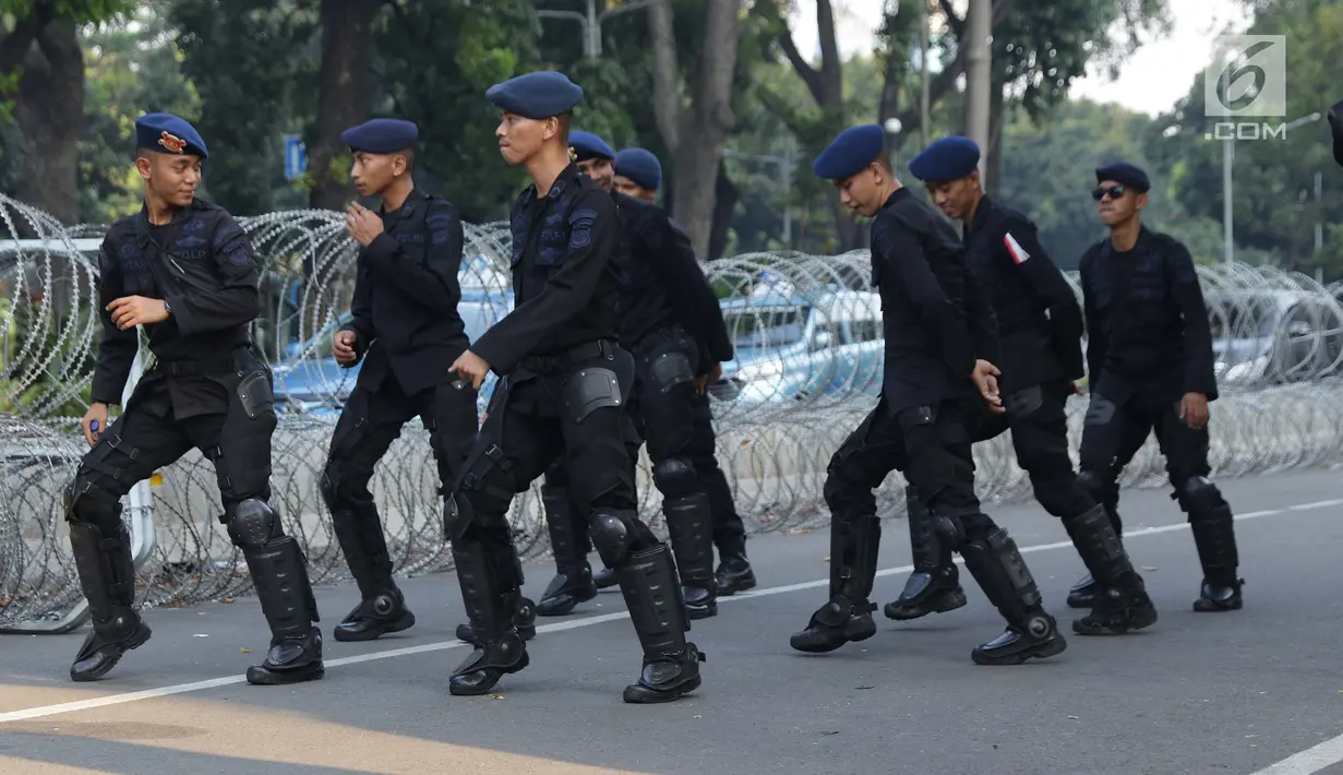Personel Brimob menari bersama disela-sela berjaga di depan Gedung Mahkamah Konstitusi (MK), Jakarta, Selasa (25/6/2019). Kegiatan ini dilakukan untuk mengusir kejenuhan disela-sela pengamanan Gedung MK jelang sidang pembacaan putusan, Kamis (27/6). (Liputan6.com/Helmi Fithriansyah)